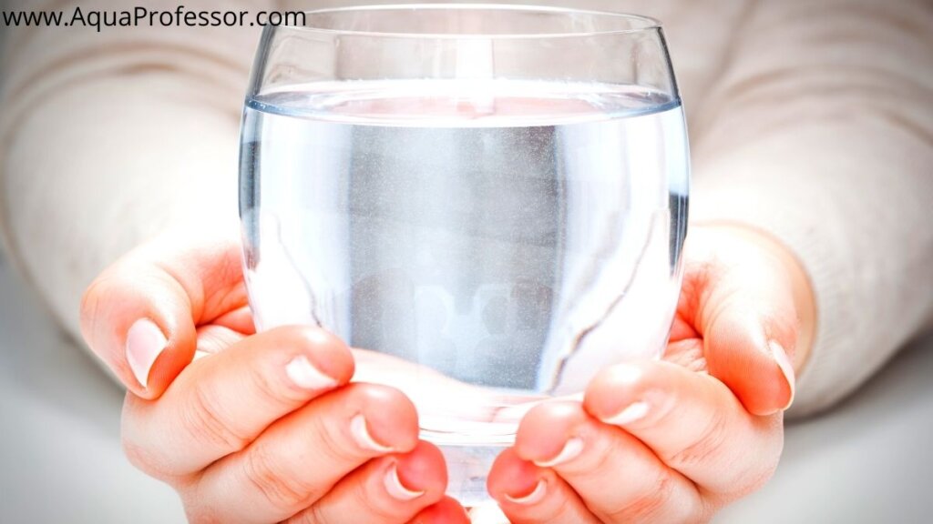 Image of two hands presenting a glass full of fresh water free from iron